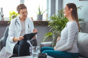 Pregnant mom talks to her ob gyn doctor.