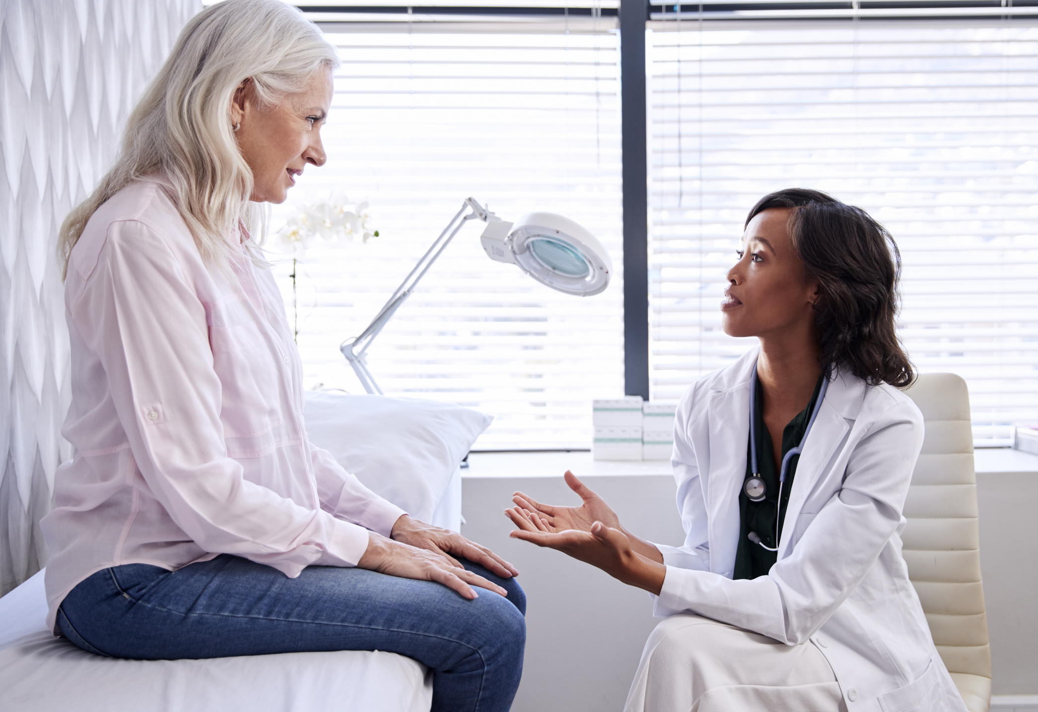 Woman talking to female doctor. 21 Questions to ask your Gastroenterologist