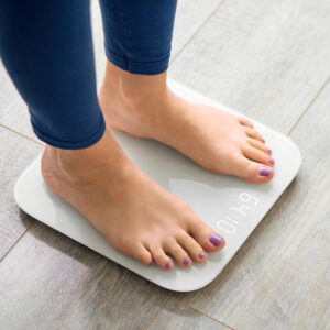 Female weighing herself on a scale