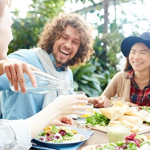 Young adults laughing and eating dinner