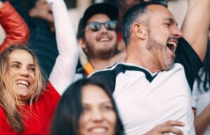 Sports fans cheering at a game.