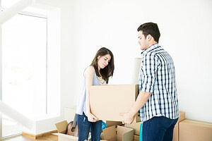 Couple working togther moving heavy objects.